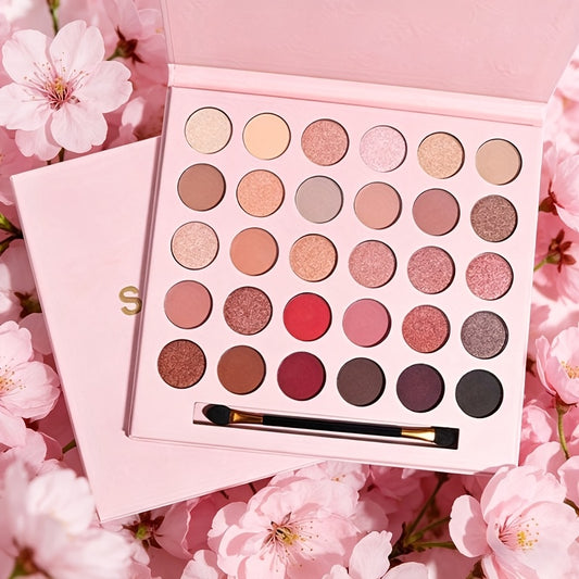 Makeup palette with eyeshadows on a pink floral background