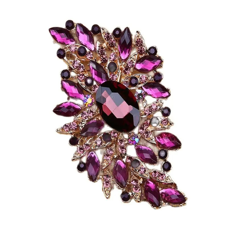 Decorative brooch with pink and purple gemstones on a white background