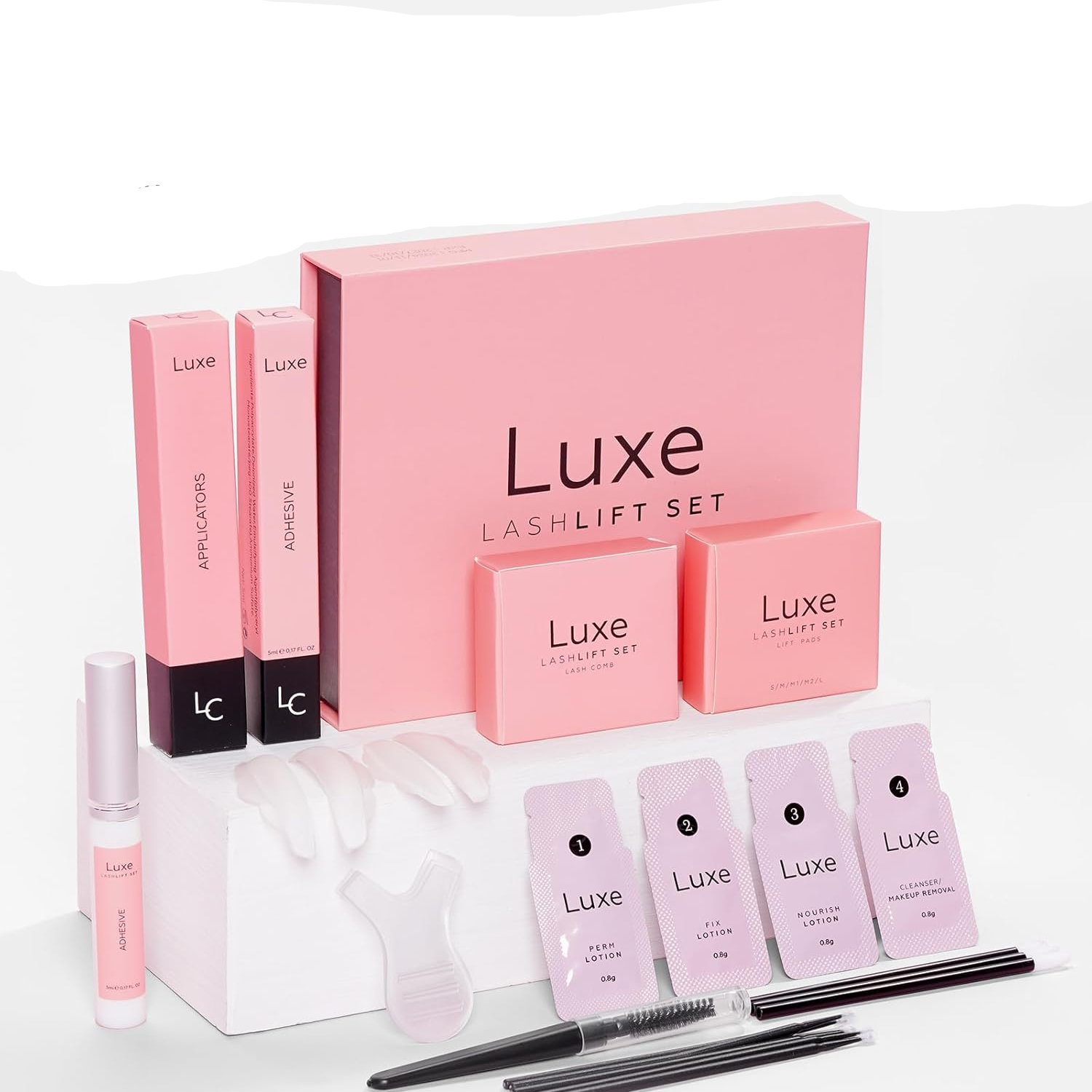 Luxe lash lift set with pink packaging and applicators on a white background