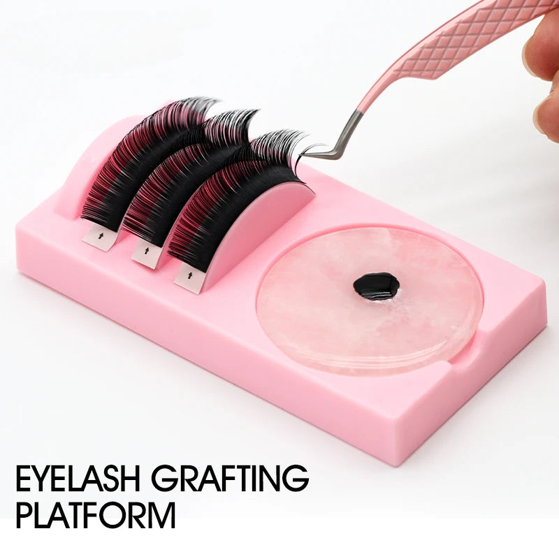 Eyelash grafting platform with false eyelashes and a tool on a white background